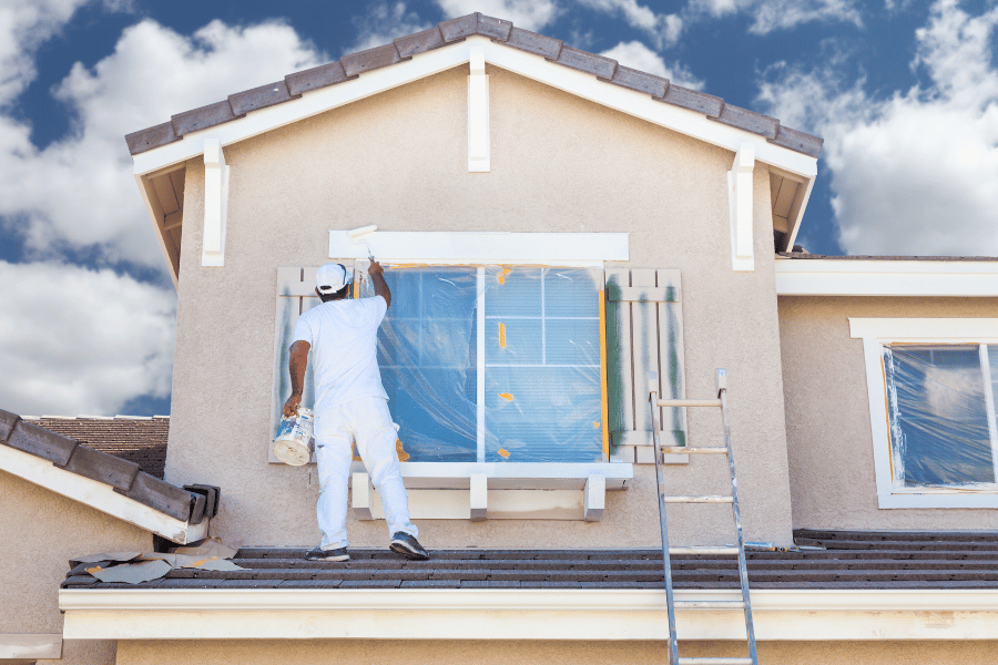 Professional Painter on the roof of a house.